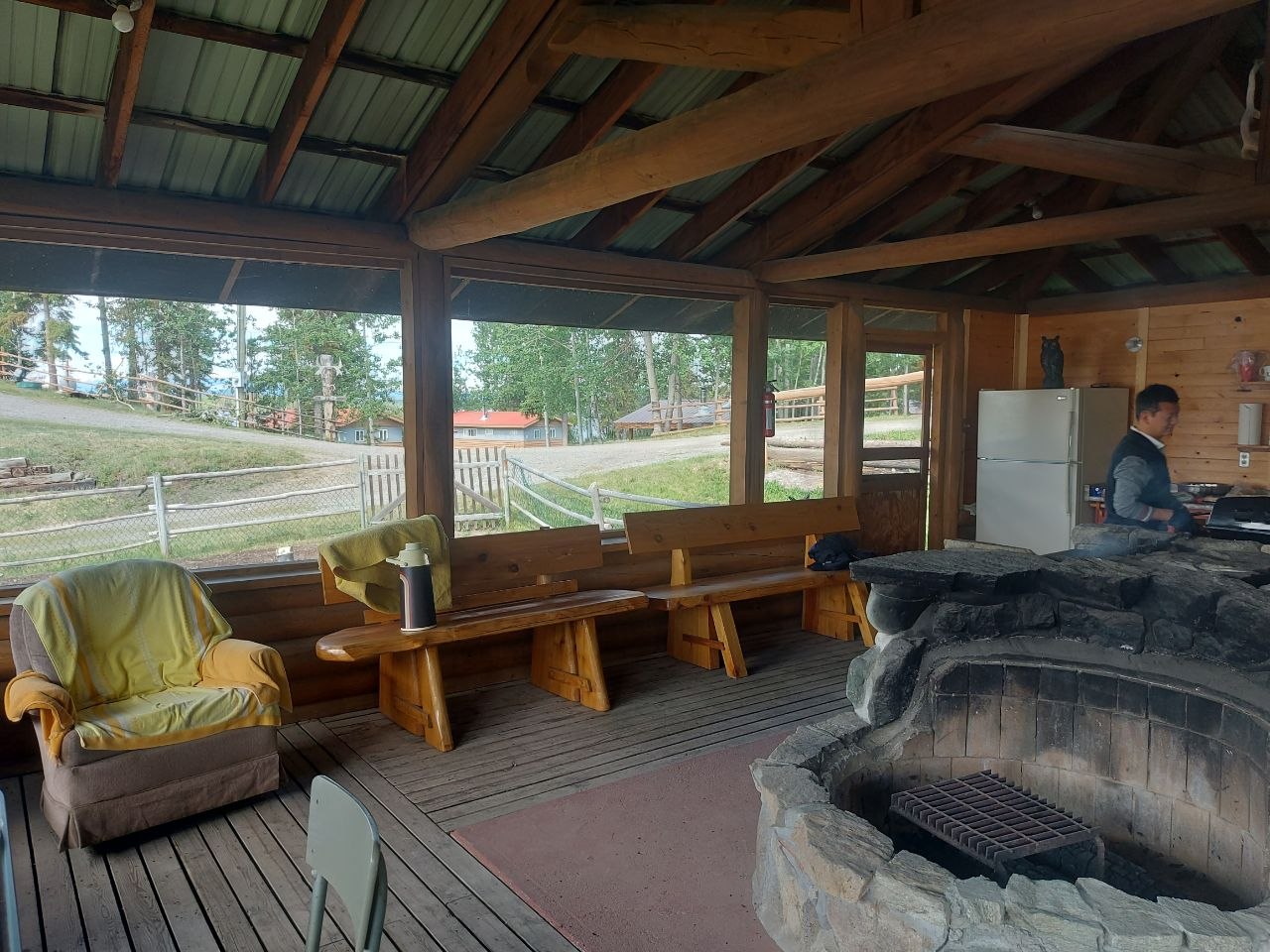 Community members grilling at a screened-in lakeside BBQ house at Lifechanyuan's Canada resort home, ...