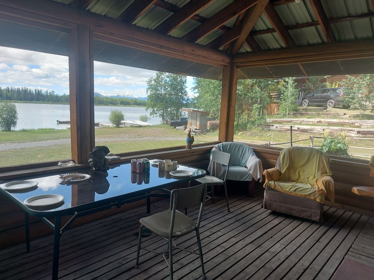 Community members grilling at a screened-in lakeside BBQ house at Lifechanyuan's Canada resort home, ...
