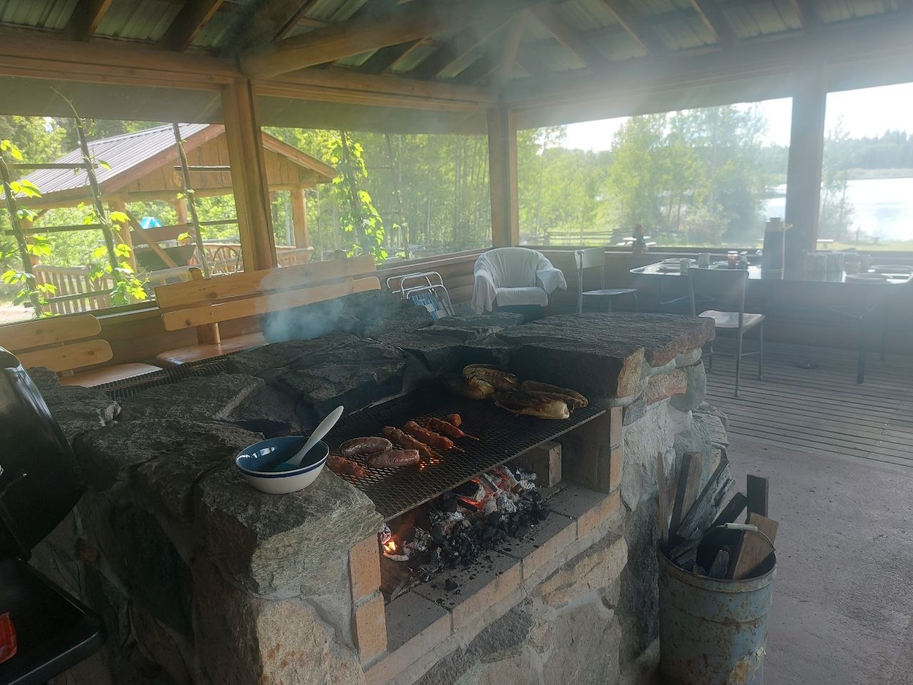 Community members grilling at a screened-in lakeside BBQ house at Lifechanyuan's Canada resort home, ...